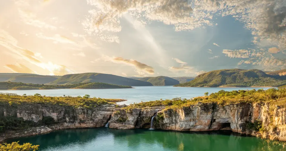 Pôr do sol sobre o lago de Furnas, com a serra e os paredões de pedra